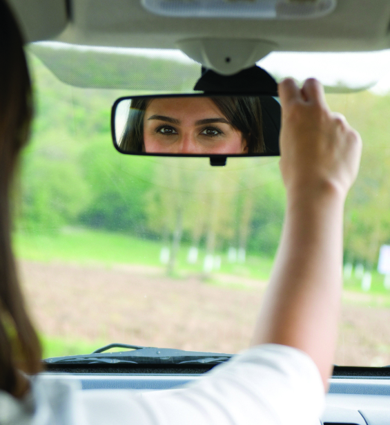 Woman checking rear view mirror