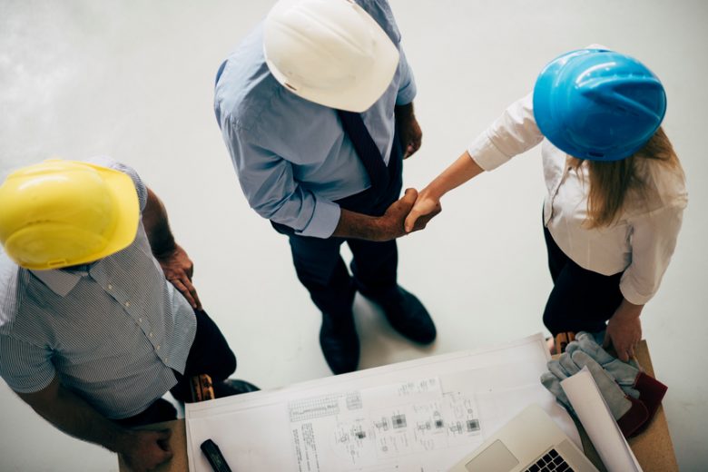 A manager shakes hands with workers