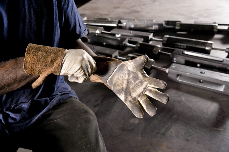 Worker putting on gloves on a job site