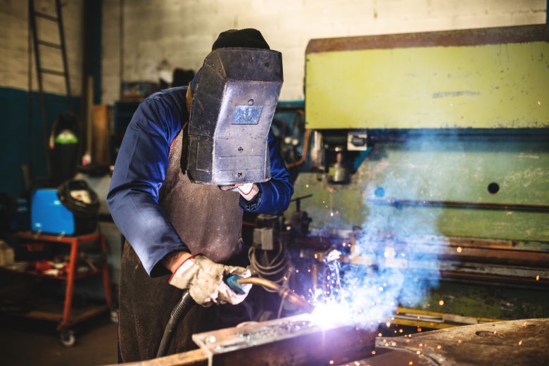 Welder in a workshop working on a piece of metal