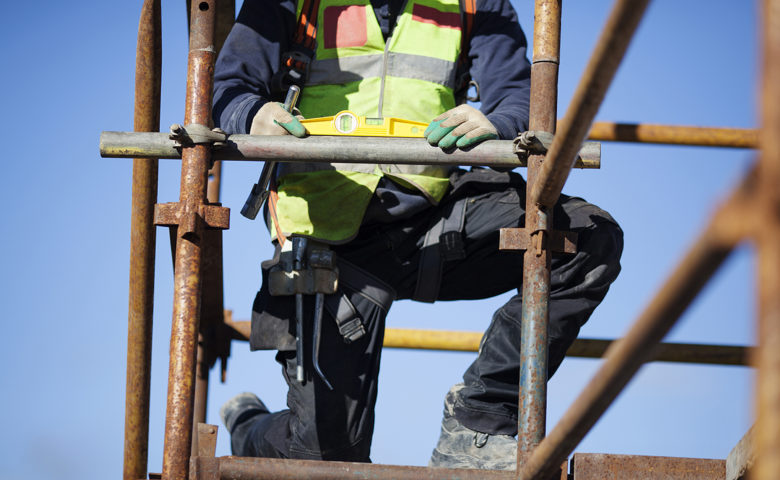 Construction worker setting up scaffolding