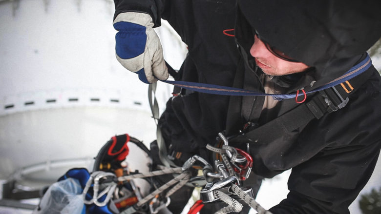 Man working at heights with tools tied off