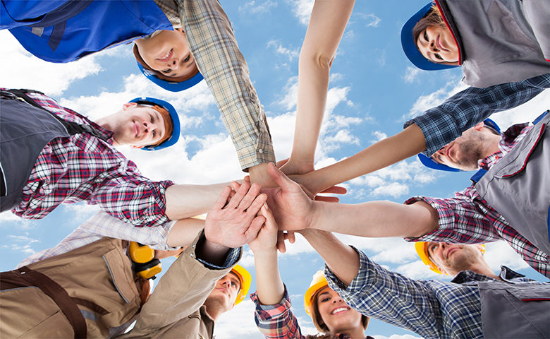 Construction workers coming together as a team
