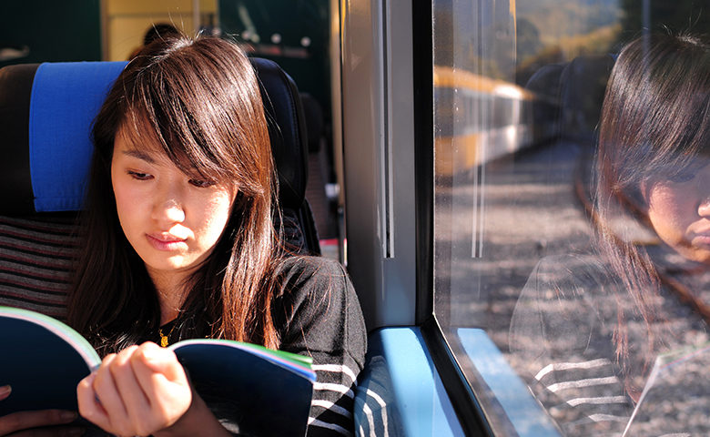 Student reading on a train