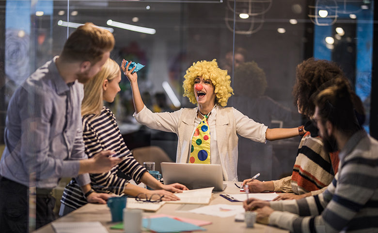 Women dressed as a clown delivering a presentation in an office