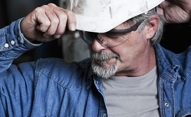 Manual worker putting on hard hat