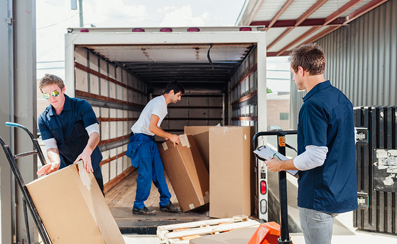 A group of dock workers are loading a delivery truck