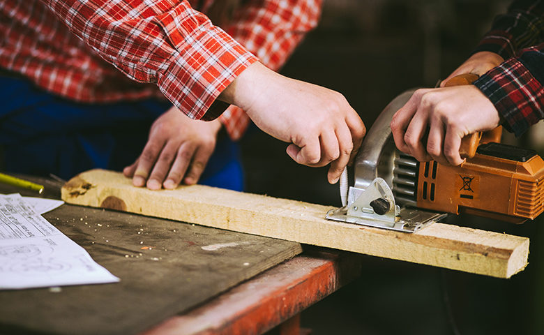 Two workers using hand tools together