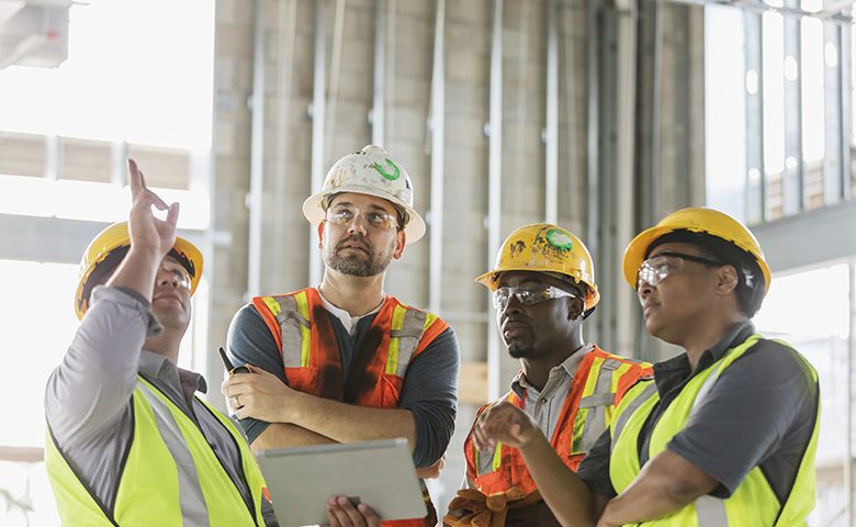 Construction workers having meeting, with digital tablet