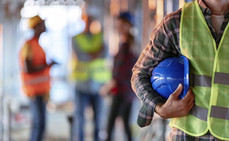 Man holding blue hardhat close up