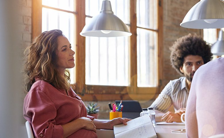 Pregnant businesswoman with colleagues in office