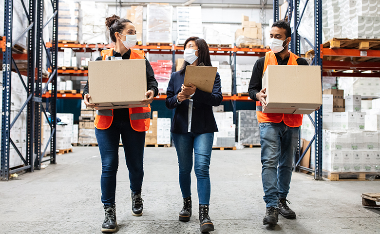 Warehouse manager with workers working during pandemic