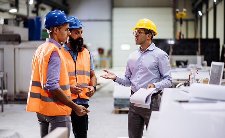 Supervisor interacting with employees in a factory.