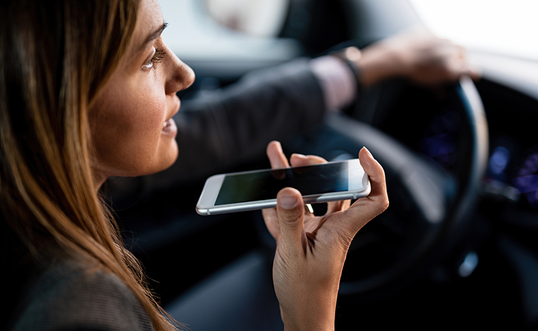 Close-up of woman talking on mobile phone while driving a car.