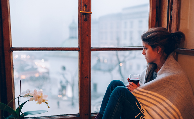 Depressed woman sitting near the window