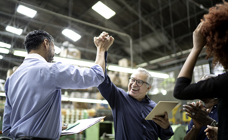 Coworkers celebrating some good news in a factory