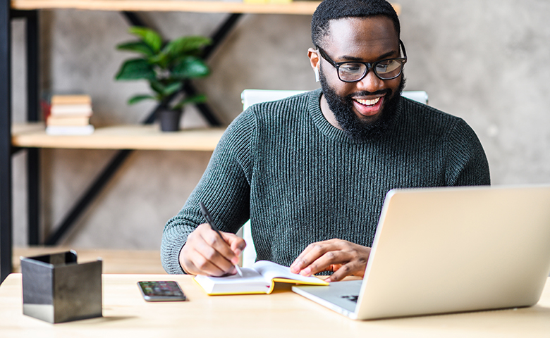 Man taking notes from a fulfilling webinar