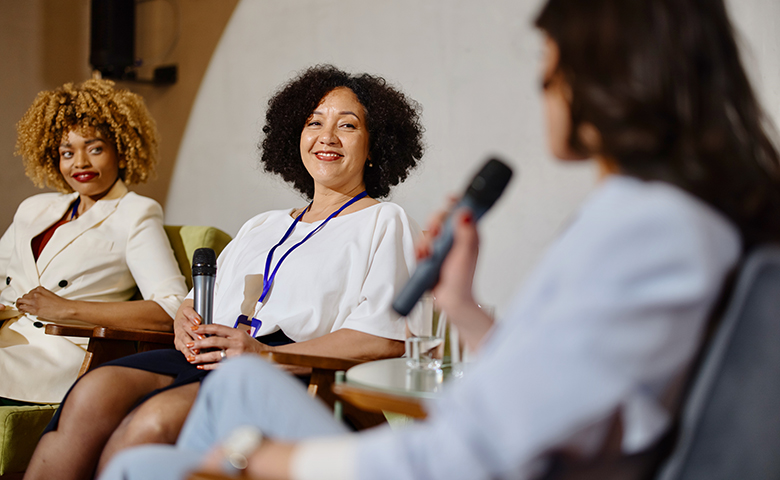 A group of experts participate in a panel session during a business conference.